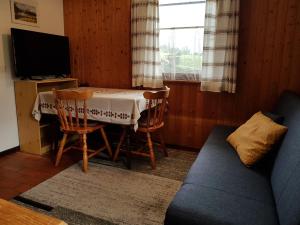 sala de estar con mesa, sillas y TV en Apartments Balon, en Kranjska Gora