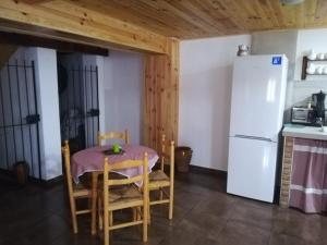 a small kitchen with a table and a refrigerator at La Herreria de Esteban in Cuevas Labradas