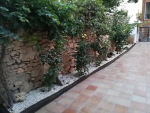 un jardín con una pared de piedra y una acera en La Herreria de Esteban, en Cuevas Labradas