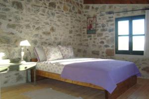 a bedroom with a bed and a table and a window at House in Organic Orgon farm in Apóstoloi
