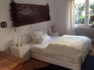 Un dormitorio con una cama blanca y una ventana. en Auszeit, en Überlingen