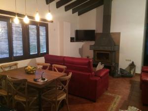 アルカラ・デル・フカルにあるCasa Rural Las Tinajas de Nayaのリビングルーム(赤いソファ、テーブル付)