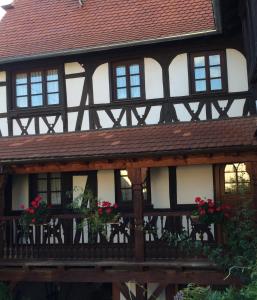 uma casa antiga com caixas de flores na varanda em Maison Dietenbeck em Wissembourg