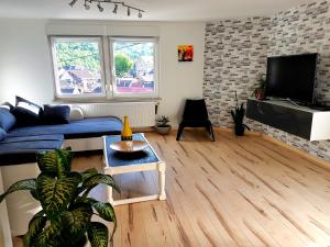 a living room with a blue couch and a tv at Ein Trip in die Natur in Bollendorf