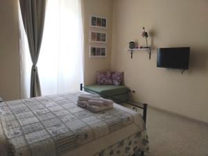 a bedroom with a bed and a chair and a television at Capital Flat 9/b in Rome