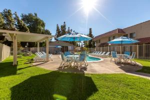 a patio with chairs and umbrellas next to a pool at Indian Palms Vacation Club in Indio