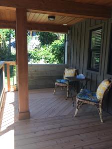 a porch with two chairs and a table on it at Cottonwood in Youbou