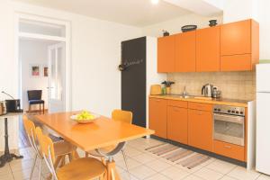 a kitchen with orange cabinets and a wooden table at Il guscio in Cadro