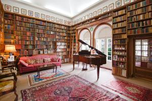 una biblioteca con un piano en una sala llena de libros en Quinta de Sao Thiago, en Sintra