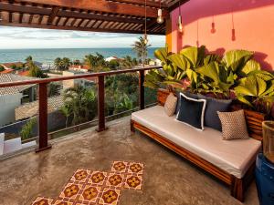 a couch on a balcony with a view of the ocean at Castelo Pink Boutique Hotel in Uruau