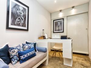 a room with a desk and a couch with a laptop at Castelo Pink Boutique Hotel in Uruau