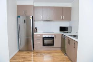 a kitchen with a stainless steel refrigerator and cabinets at The Griff Motel in Griffith