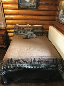 Bett mit Tagesdecke und Hirsch drauf in der Unterkunft Gwin's Lodge & Roadhouse in Cooper Landing