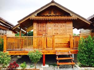 a wooden cabin with a porch and a bench at Imsuk Homestay at Chiang Rai in Chiang Rai +13 photos