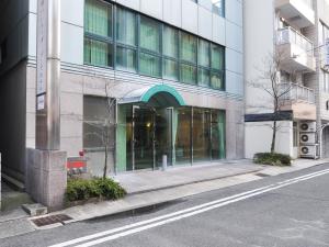 un edificio con una puerta de cristal en una calle en Kobe City Gardens Hotel (Formally Hotel Kobe Shishuen), en Kobe