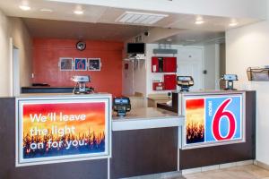 a store with two signs on the counter in a room at Motel 6-Kalispell, MT in Kalispell