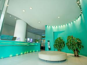 a lobby with a round table and a plant at Jingjiang Inn Taiyuan Fuxi Street Wanda Plaza in Taiyuan