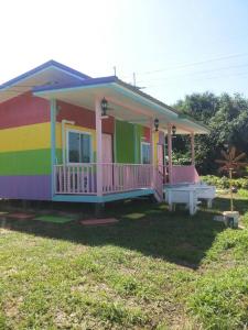 a rainbow colored house with a yard at Baan Oei Erng in Ban Laem Ngiu