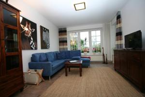 a living room with a blue couch and a tv at Ferienwohnung Templin in Templin