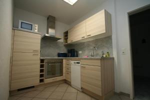 a kitchen with wooden cabinets and a white refrigerator at Ferienwohnung Templin in Templin