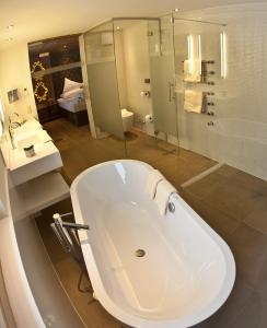 マイヤーホーフェンにあるStock Apartmentsのバスルーム(大きな白いバスタブ、シャワー付)