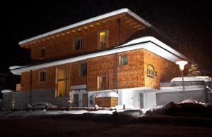 a large brick building with snow on it at night at Stock Apartments in Mayrhofen