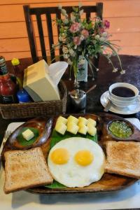 einen Teller mit Eiern und Brot auf dem Tisch in der Unterkunft Gap's house in Chiang Mai