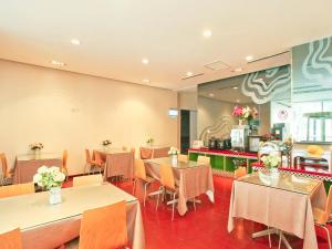 une salle à manger avec des tables et des chaises dans un restaurant dans l'établissement Jinjiang Inn Select Taiyuan Tongluowan Wuyi Road, à Taiyuan