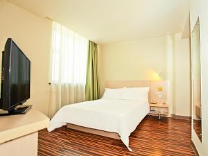 太原的住宿－錦江之星風尚太原銅鑼灣五一路酒店，一间卧室配有一张床和一台平面电视