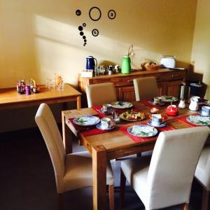 einem Esstisch mit Stühlen und einem Tisch mit Essen darauf in der Unterkunft L&L Skaters Home in Langenlipsdorf