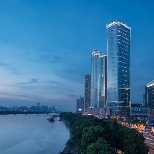 a city with tall buildings and boats on the water at Grand Hyatt Changsha in Changsha