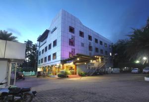 科泽科德Park Residency Airport Road的前面有停车场的大型白色建筑