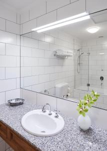 W białej łazience znajduje się umywalka i lustro. w obiekcie The Terrace at The Settlement w mieście Cranbourne