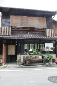 京都的住宿－畫廊諾澤酒店，街道边有盆栽植物的建筑