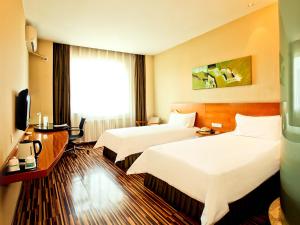 a hotel room with two beds and a television at Jinjiang Inn Select Taiyuan Liu Lane Yangshi Street in Taiyuan