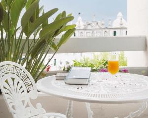 een witte tafel met een laptop en een glas sinaasappelsap bij Cardal Hotel in Pombal