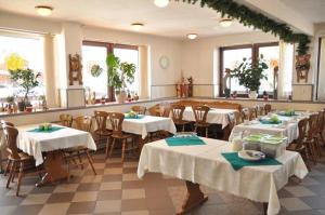 カルパチにあるOśrodek Wypoczynkowy Pod Stokiemのテーブルと椅子(白いテーブルクロス付)が備わるレストラン