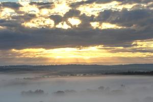 a view of a foggy sunrise with the sun shining through the clouds at The Block Vista B&B in Nanango