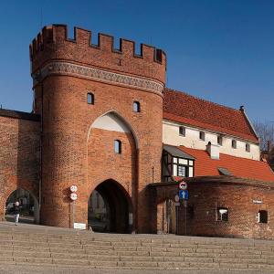 ein großes Backsteingebäude mit einem Torbogen davor in der Unterkunft Apartament Pod Kopernikiem II in Toruń