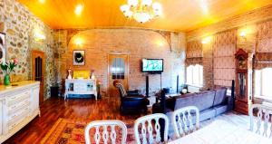 uma sala de estar com um sofá, uma mesa e cadeiras em Ansera Residence Sheki em Sheki