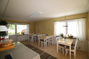 a living room with tables and chairs and windows at Borlänge Vandrarhem & Turistlägenheter in Borlänge
