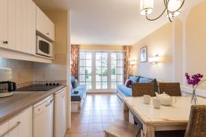 eine Küche und ein Wohnzimmer mit einer Couch und einem Tisch in der Unterkunft Résidence Pierre & Vacances Le Domaine de Bordaberry in Urrugne