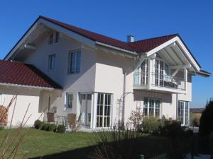 a white house with a red roof at Ferienwohnung am Golfplatz in Grassau