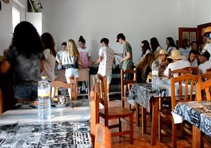 a group of people sitting at tables in a room at Watsay Surf House in Santoña
