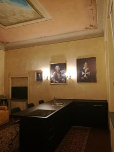 ボローニャにあるPalazzo Bargellini Panzacchi Rooms & Apartmentのバスルーム(シンク付)が備わります。壁には絵画が飾られています。