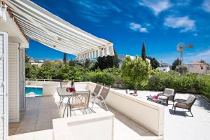 een patio met een tafel en stoelen en een hek bij Merab Center Villas in Ayia Napa