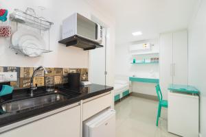 uma cozinha com um lavatório e um micro-ondas em Villa Sophia em São Paulo