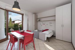 ペスキエーラ・デル・ガルダにあるSan Benedetto di Lugana 2のベッドルーム1室(ベッド1台、テーブル、赤い椅子付)