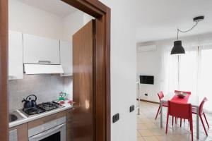 una cucina con tavolo con sedie rosse e una sala da pranzo di San Benedetto di Lugana 2 a Peschiera del Garda