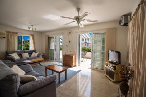 a living room with a couch and a tv at Merab Center Villas in Ayia Napa